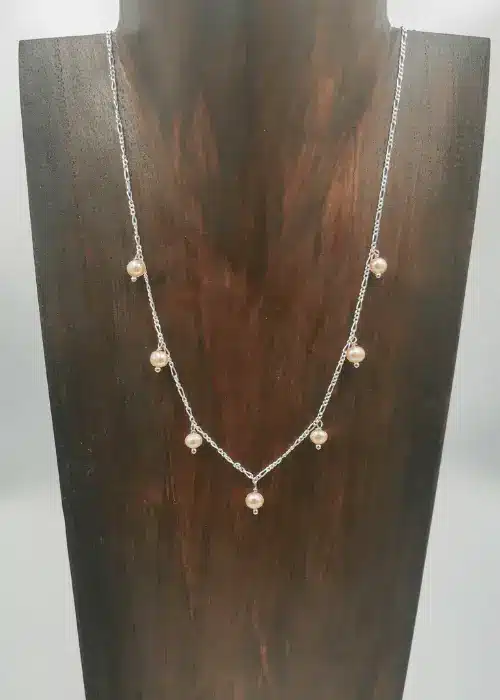 Petite peach freshwater pearls on a 45cm sterling silver Figaro chain.